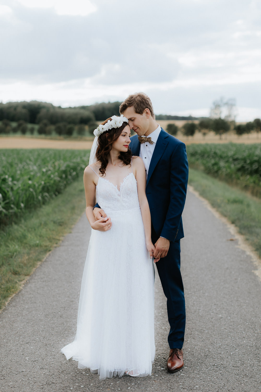 Brautpaar Hand in Hand auf Landstraße – dokumentarische Hochzeitsfotografie in Potsdam